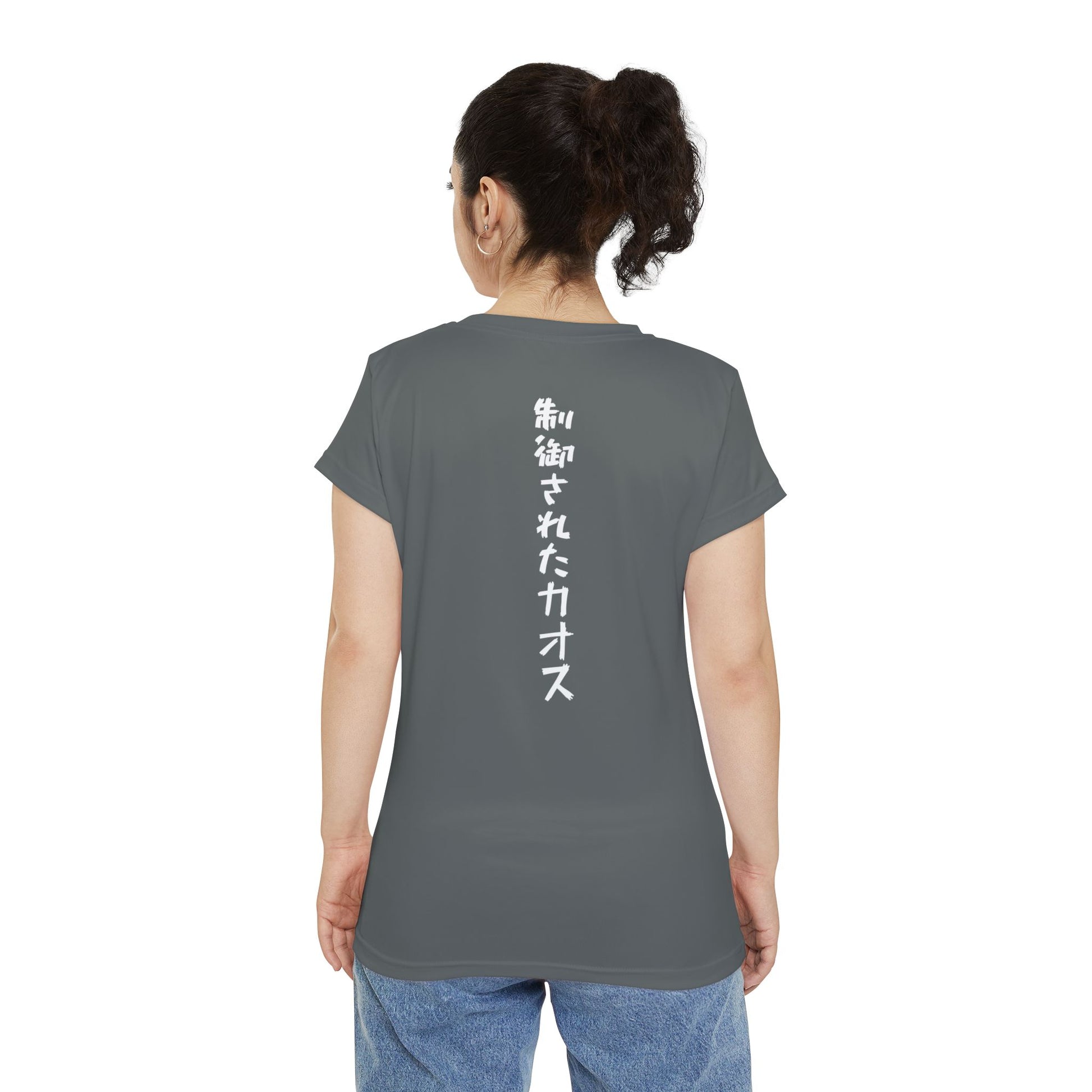 Back view of a woman wearing a dark gray, polyester blend t-shirt, with the words "Controlled Chaos" written vertically down the middle of the shirt in Japanese.