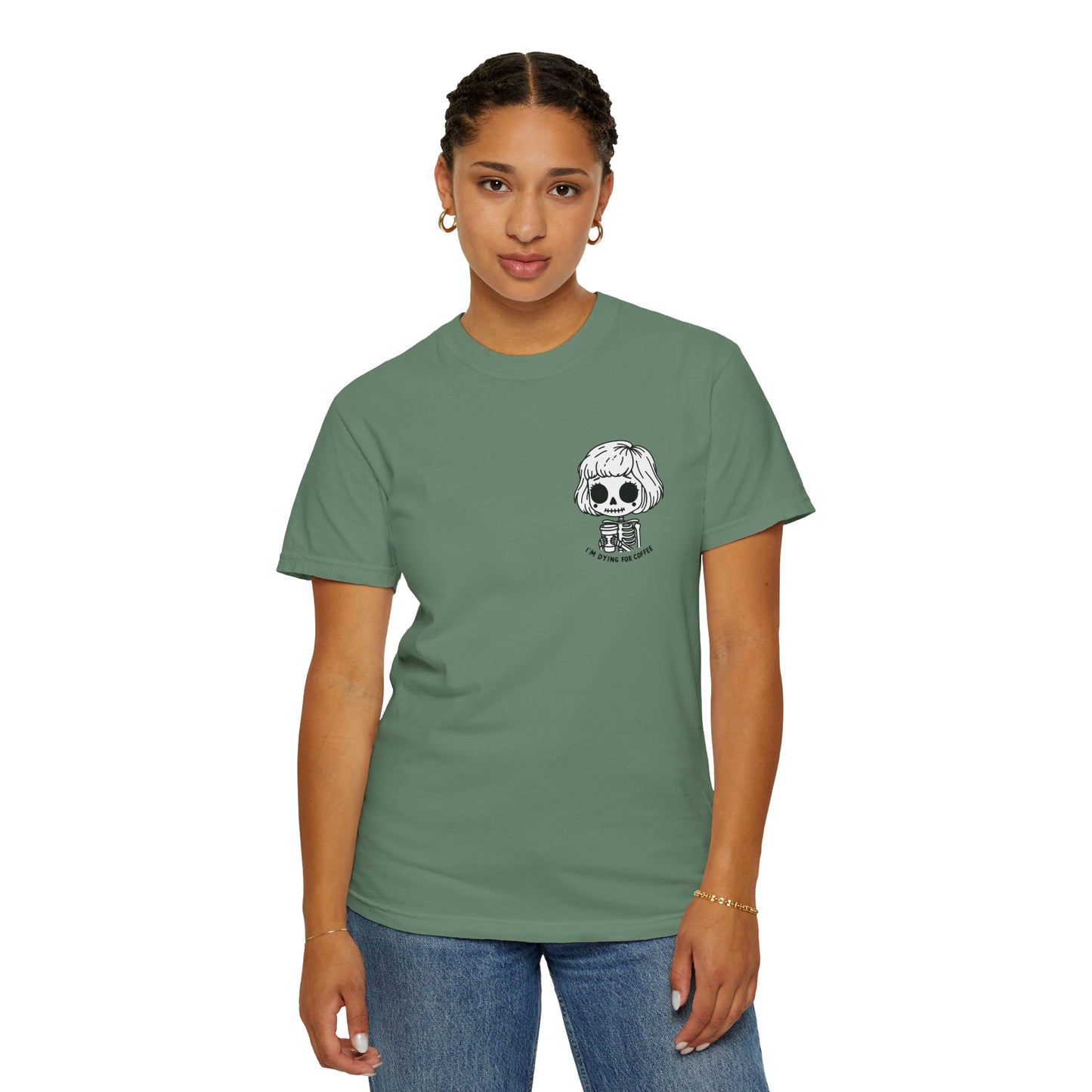 Alternate view of a woman wearing a Light Green colored t-shirt with a design of a skeleton girl holding a cup of coffee printed on the front. Written underneath the design is the text, "I'm dying for coffee". The design is placed on the left chest area of the t-shirt.