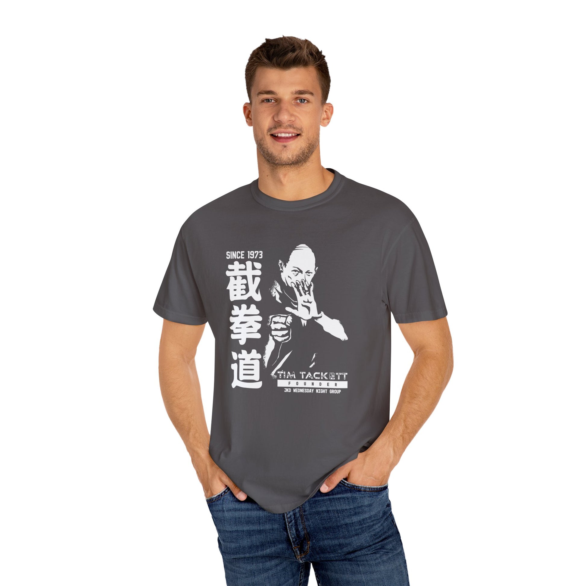 Man wearing a Graphite colored, cotton t-shirt with an illustration of martial arts instructor Tim Tackett on the front. The text surrounding the design reads "Jeet Kune Do since 1973".