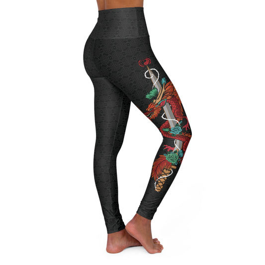 Right side view of black, patterned yoga leggings with a large design of a dragon wrapped around a sword. The design is placed vertically on the right leg.