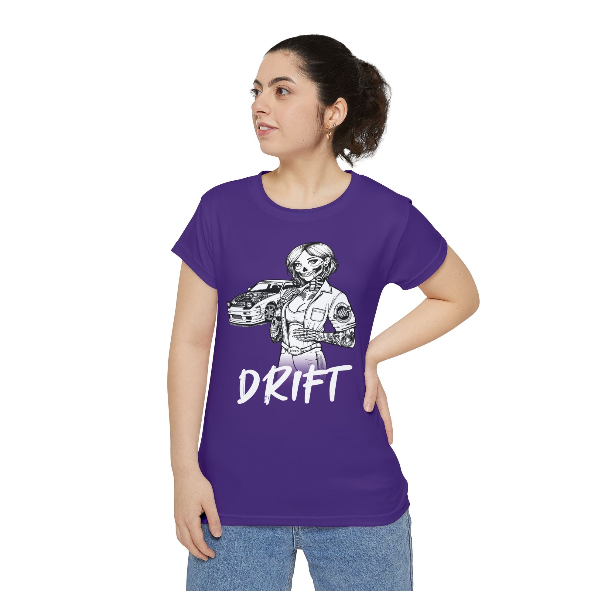 Front view of a woman wearing a purple, polyester blend t-shirt, with a design of a female skeleton dressed as a mechanic. The mechanic is standing next to her car with the word "Drift" written underneath.