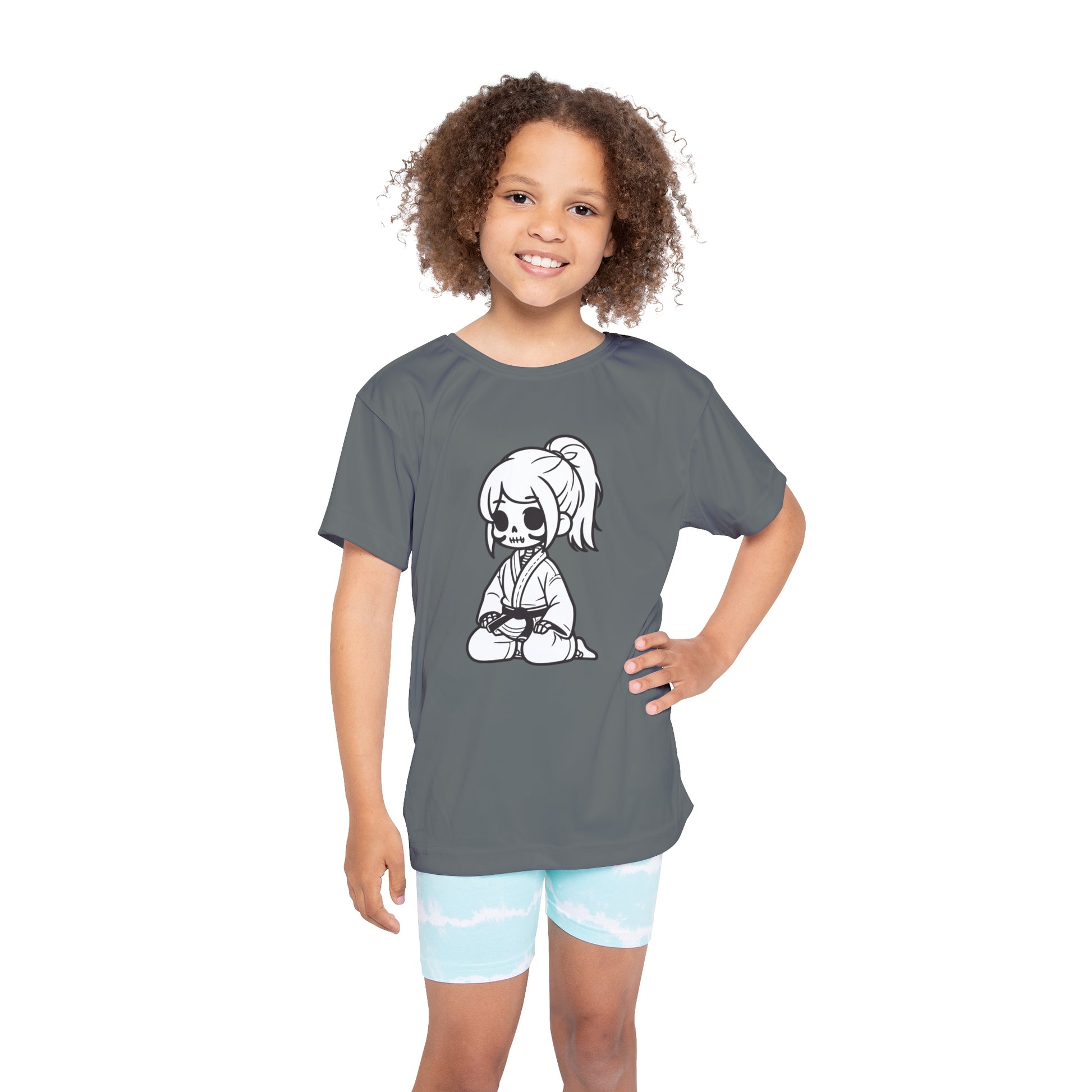 Front view of a girl wearing a dark gray, polyester kids t-shirt, with a design of a skeleton girl wearing a jiu jitsu gi and black belt on the front.