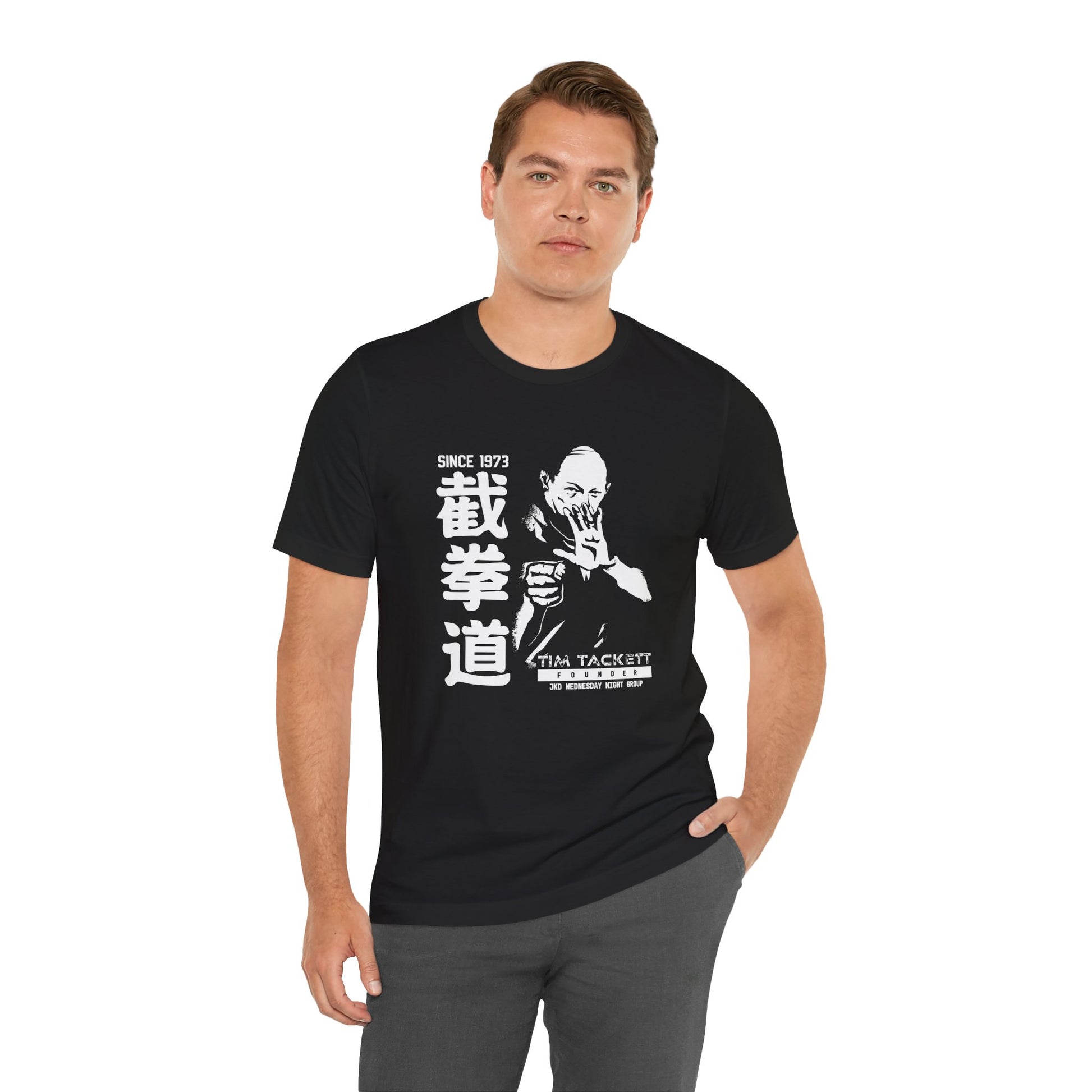 Alternate view of a man wearing a black cotton t-shirt, with an illustration of martial arts instructor Tim Tackett. The text surrounding the design reads "Jeet Kune Do since 1973".