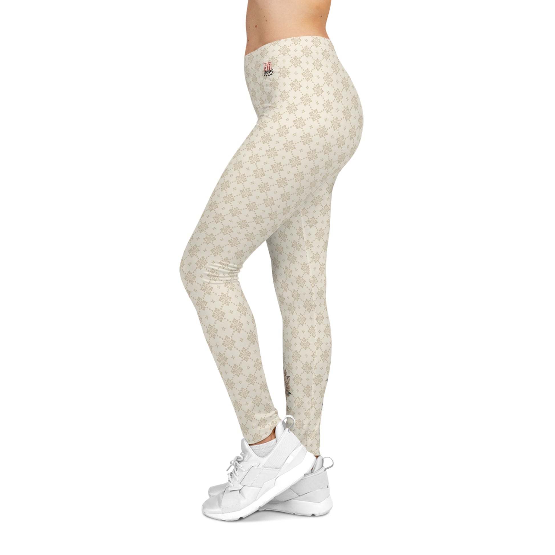 Left side view of a woman wearing off-white colored patterned leggings, with the MartialBoutique logo printed on the upper left hip area.