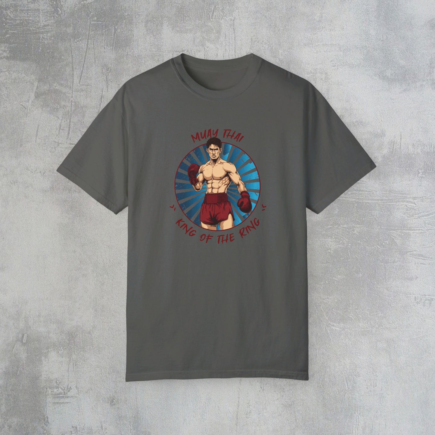 Pepper colored, relaxed fit cotton t-shirt, with an illustration of a Thai boxer in the center of the chest. Written around the illustration is the text, "Muay Thai - King of the Ring".