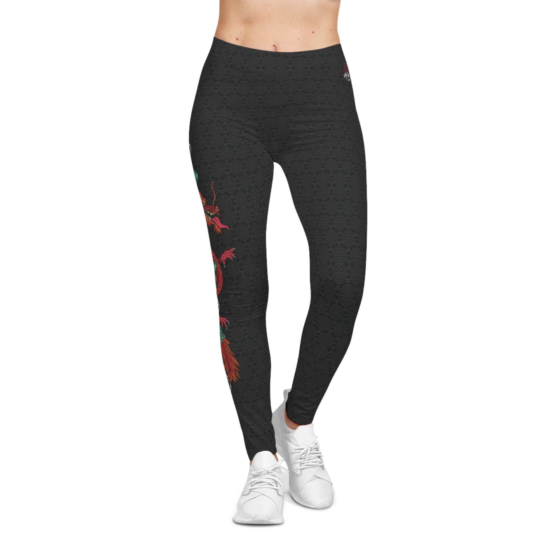 Front view of black, patterned low-rise leggings, with a large design of a dragon wrapped around a sword. The design is placed vertically on the right leg.