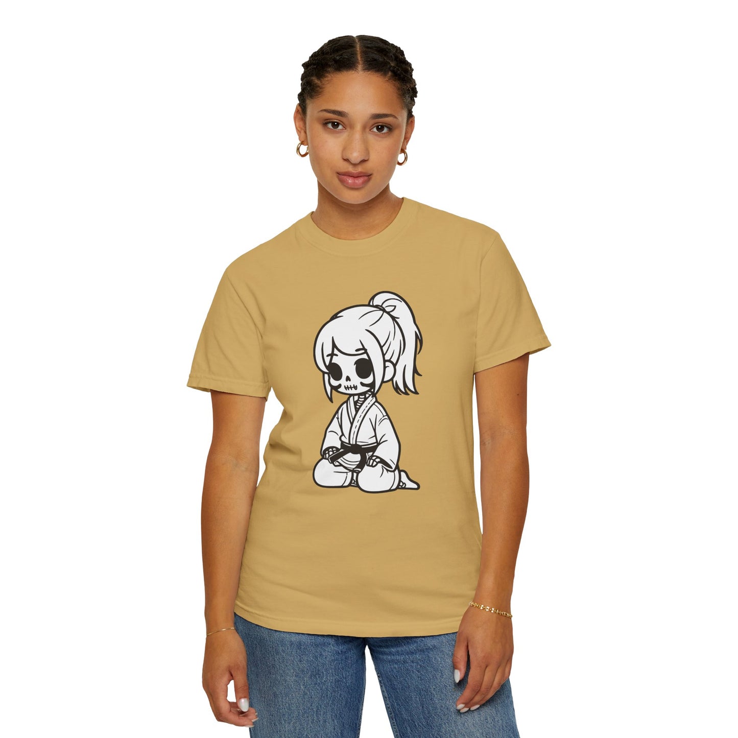 Front view of a woman wearing a mustard colored cotton t-shirt, with a design of a skeleton girl wearing a jiu jitsu gi printed on the front of the shirt.