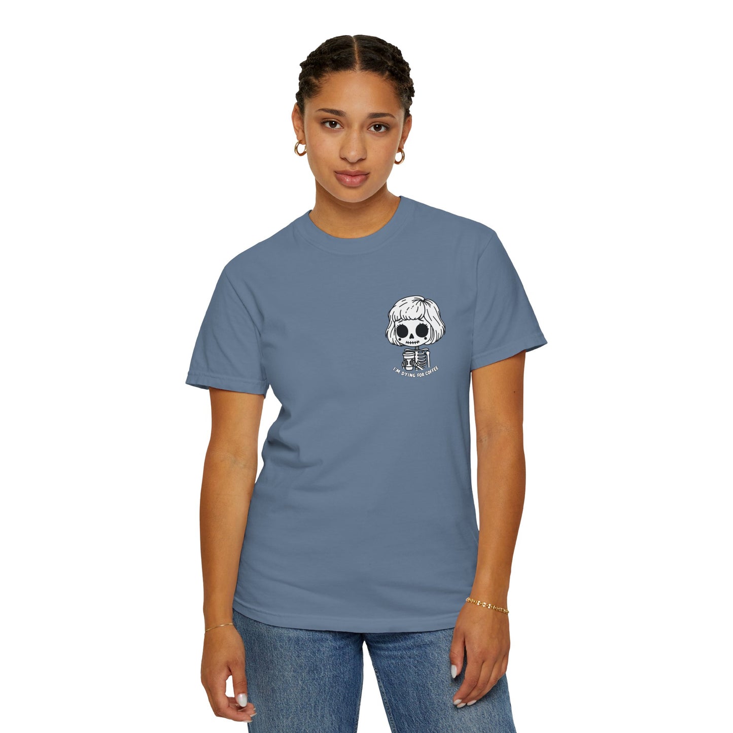 Alternate view of a woman wearing a Blue Jean colored t-shirt with a design of a skeleton girl holding a cup of coffee printed on the front. Written underneath the design is the text, "I'm dying for coffee". The design is placed on the left chest area of the t-shirt.