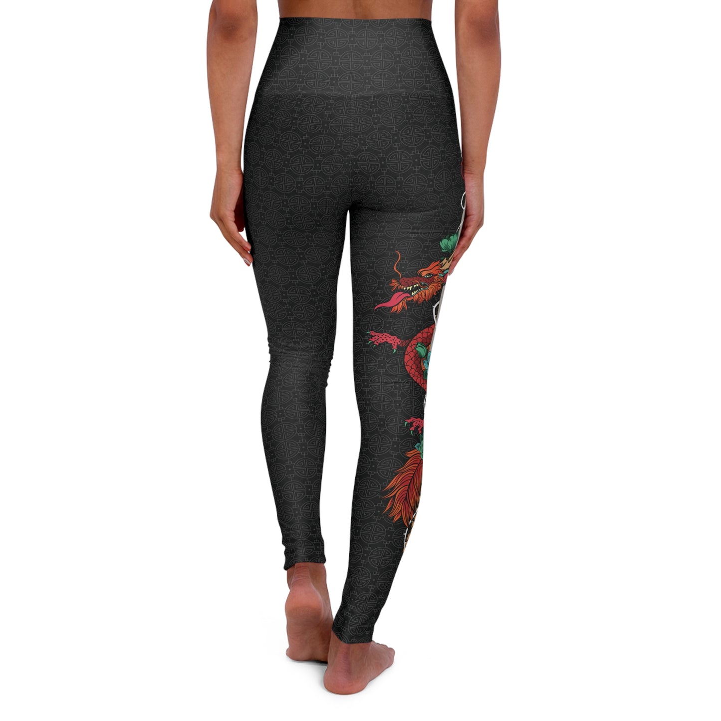 Back view of black, patterned yoga leggings with a large design of a dragon wrapped around a sword. The design is placed vertically on the right leg.