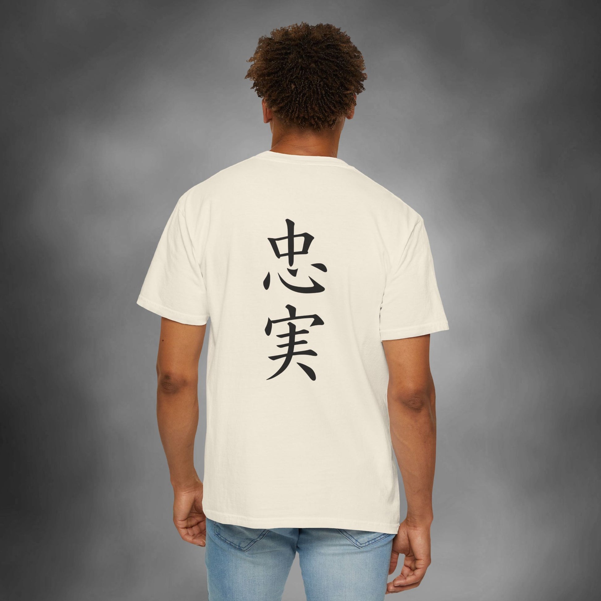 Back view of a man wearing an ivory colored cotton t-shirt, with the kanji for "Loyal" printed vertically down the middle.