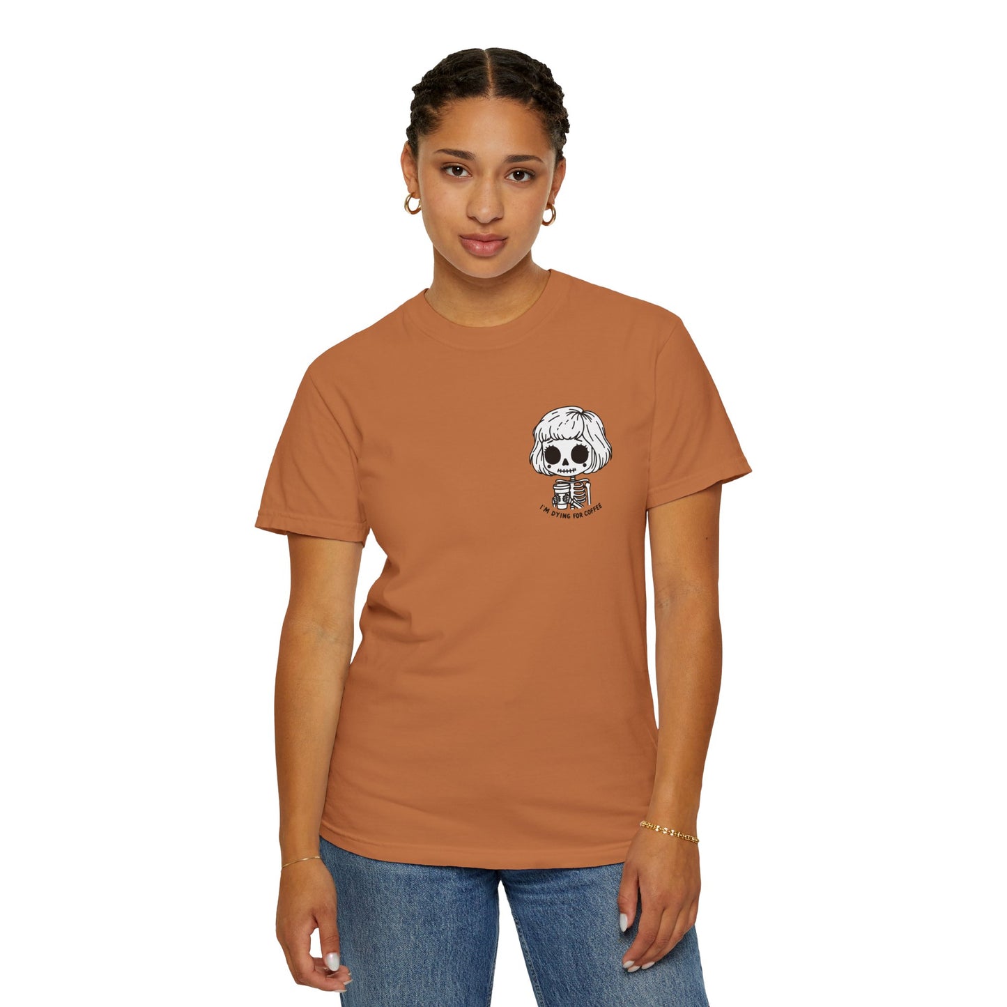 Alternate view of a woman wearing a Yam colored t-shirt with a design of a skeleton girl holding a cup of coffee printed on the front. Written underneath the design is the text, "I'm dying for coffee". The design is placed on the left chest area of the t-shirt.