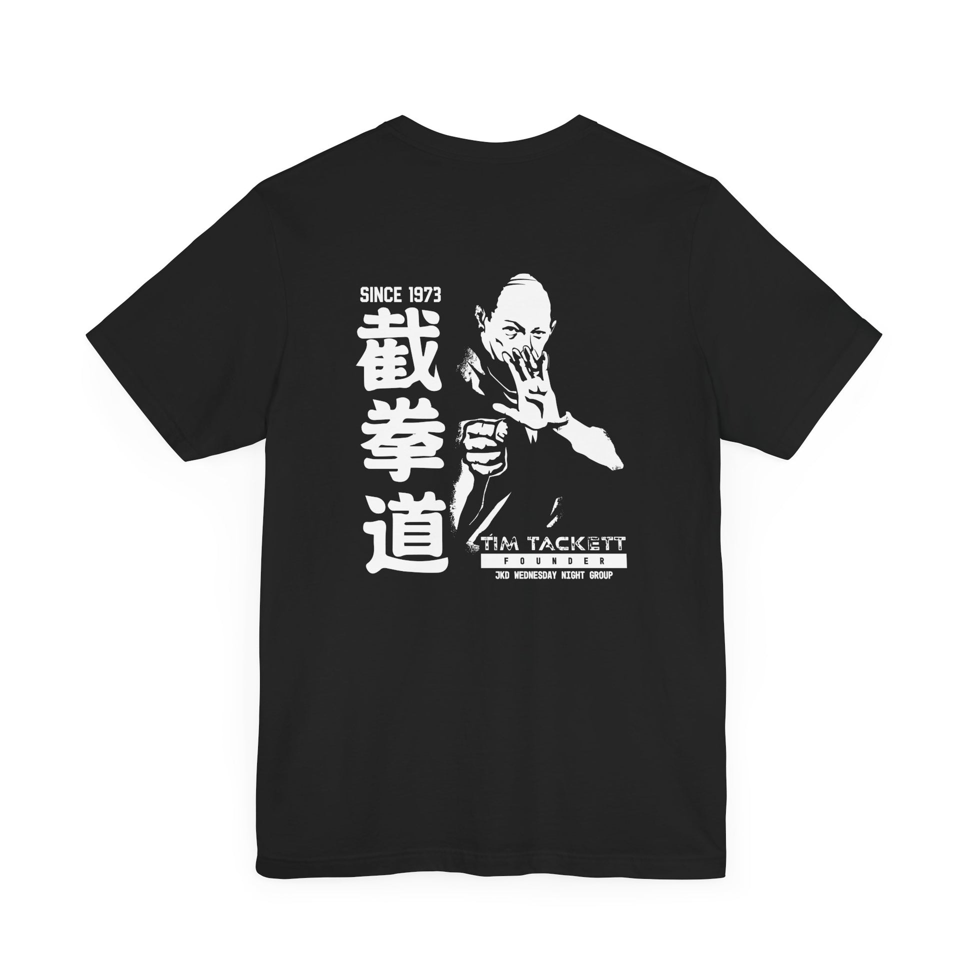 Back view of a black cotton t-shirt, with an illustration of martial arts instructor Tim Tackett. The text surrounding the design reads "Jeet Kune Do since 1973".