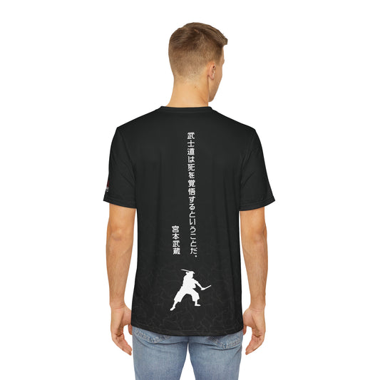 Back view of a man wearing a black polyester t-shirt, with modern Japanese text written vertically that reads "Bushido means being prepared to die." Below the text is a silhouette image of Miyamoto Musashi wielding two swords.