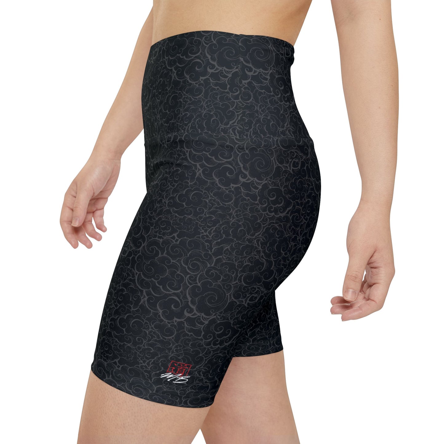 Left side view of a woman wearing black patterned gym shorts with a high waist. The MartialBoutique logo is printed on the left thigh.