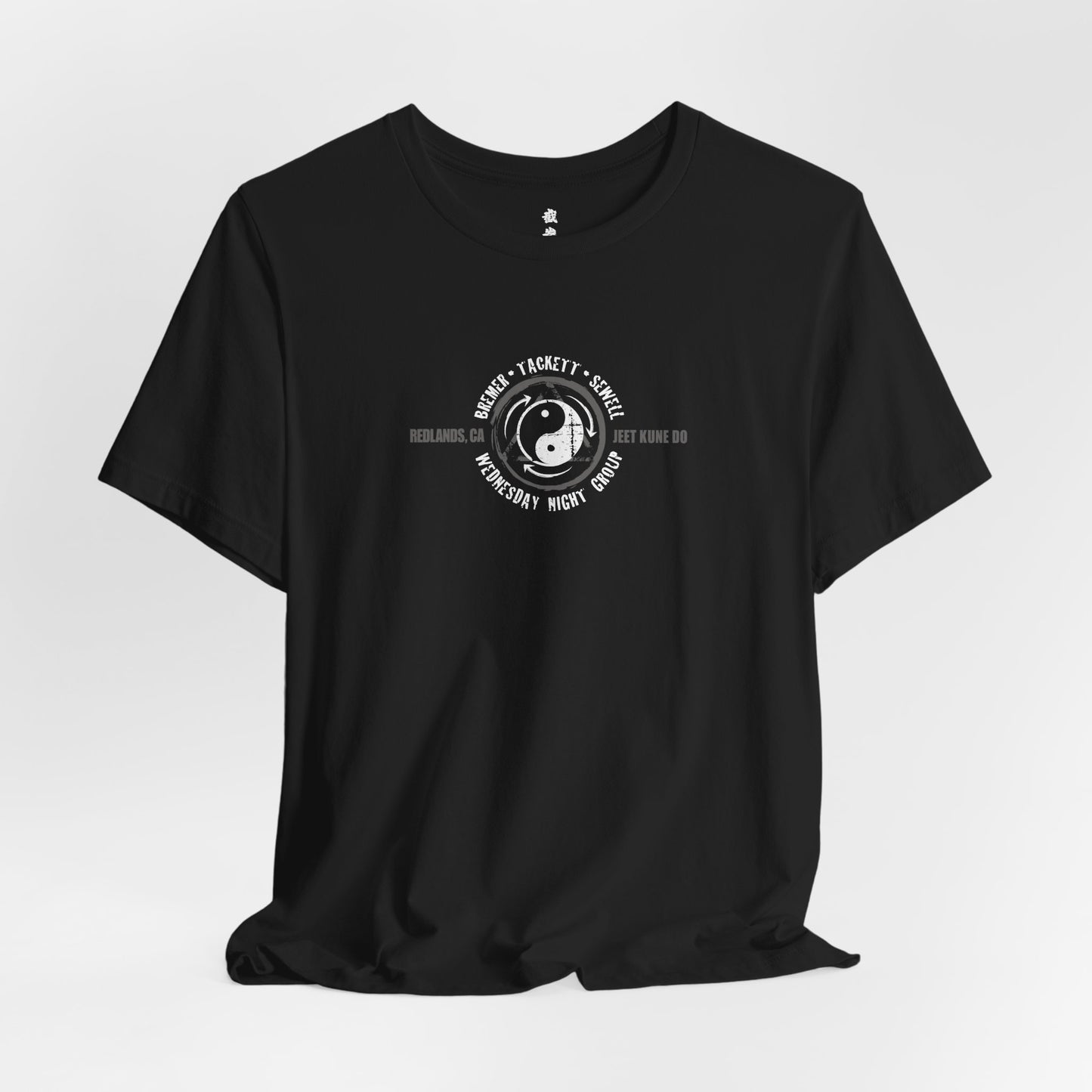 Alternate front view of a black cotton t-shirt, with the JKD Wednesday Night Group logo printed on the chest.