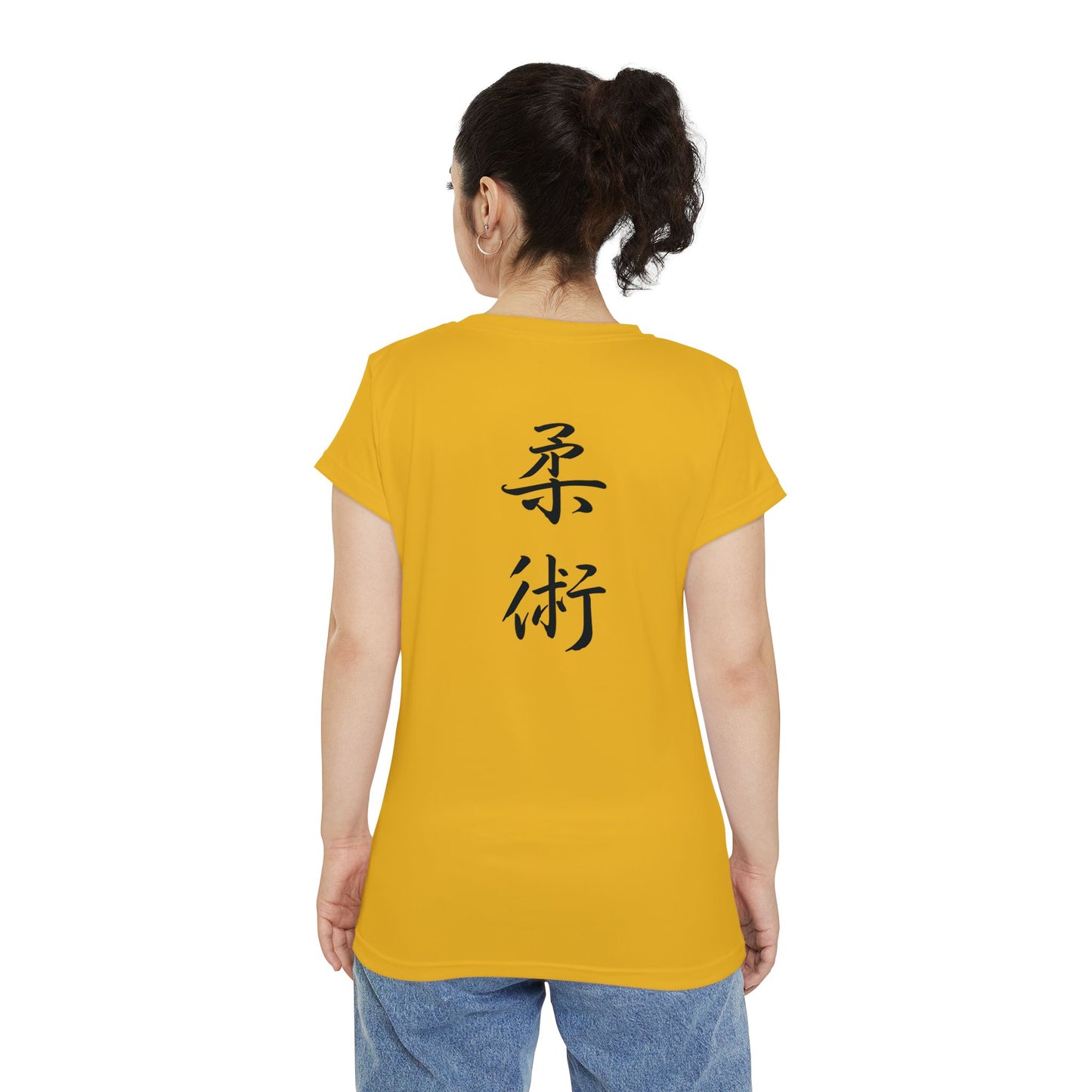 Back view of a woman wearing a yellow polyester blend t-shirt, with the kanji symbols for Jiu Jitsu printed vertically down the middle of the shirt.