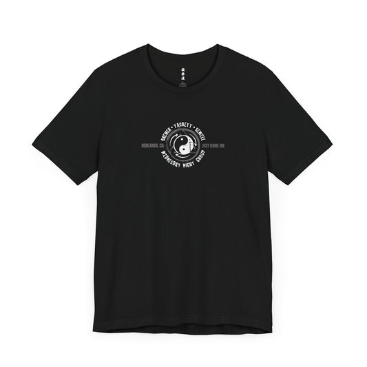 Front view of a black cotton t-shirt, with the JKD Wednesday Night Group logo printed on the chest.