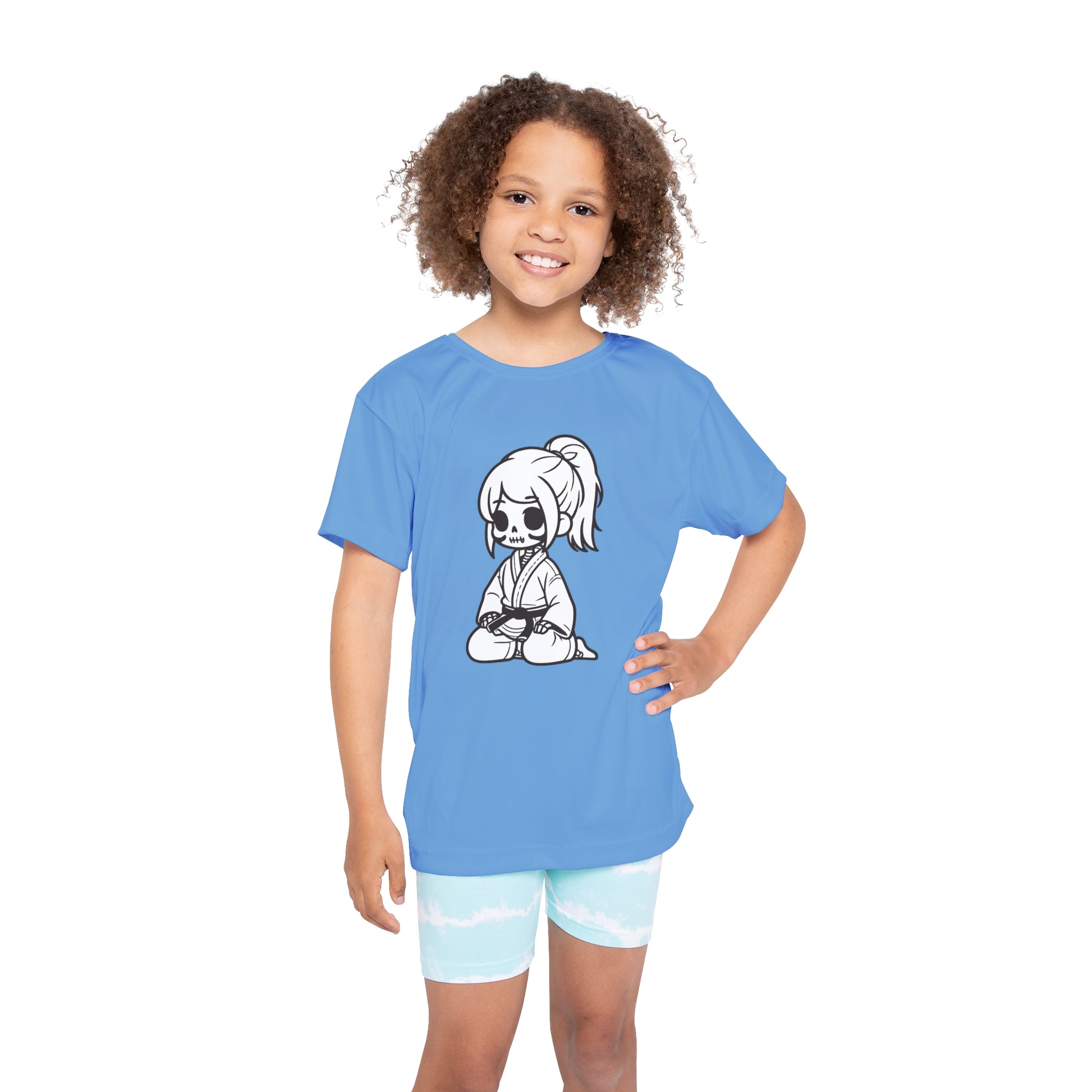 Front view of a girl wearing a light blue, polyester kids t-shirt, with a design of a skeleton girl wearing a jiu jitsu gi and black belt on the front.