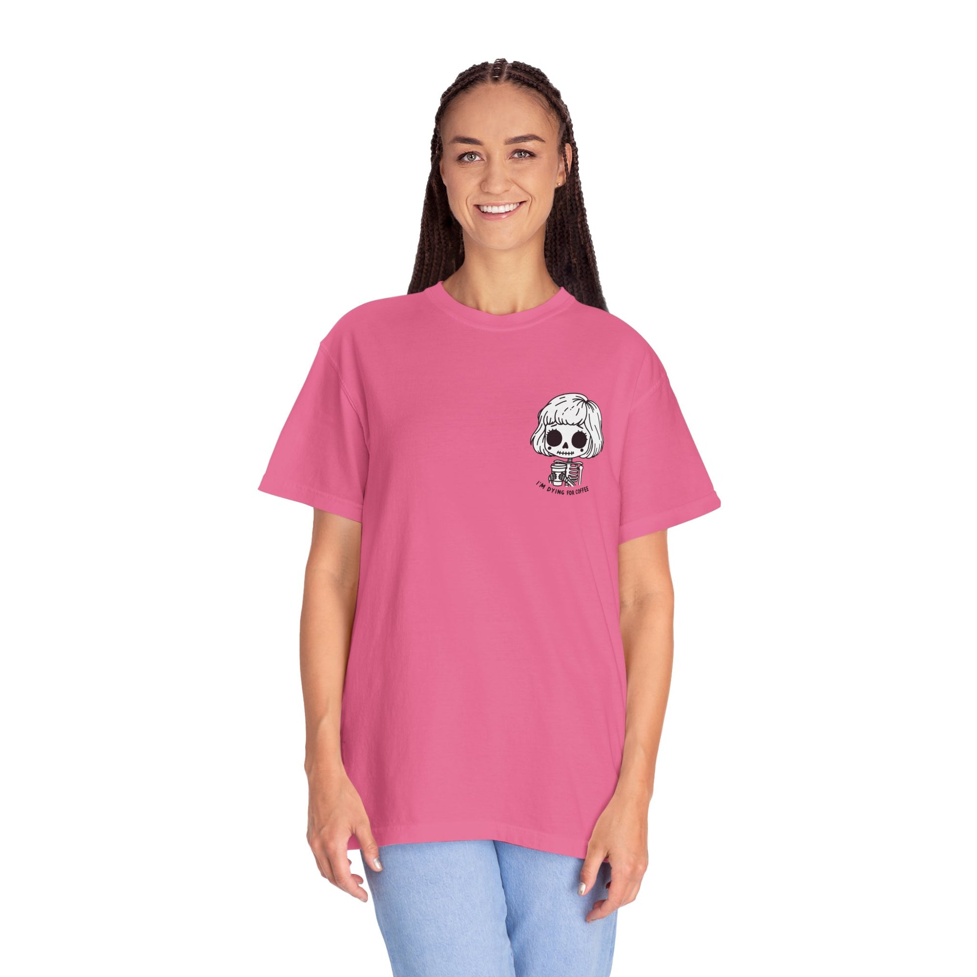 Alternate view of a tall, thin woman wearing a Crunchberry colored t-shirt with a design of a skeleton girl holding a cup of coffee printed on the front. Written underneath the design is the text, "I'm dying for coffee". The design is placed on the left chest area of the t-shirt.