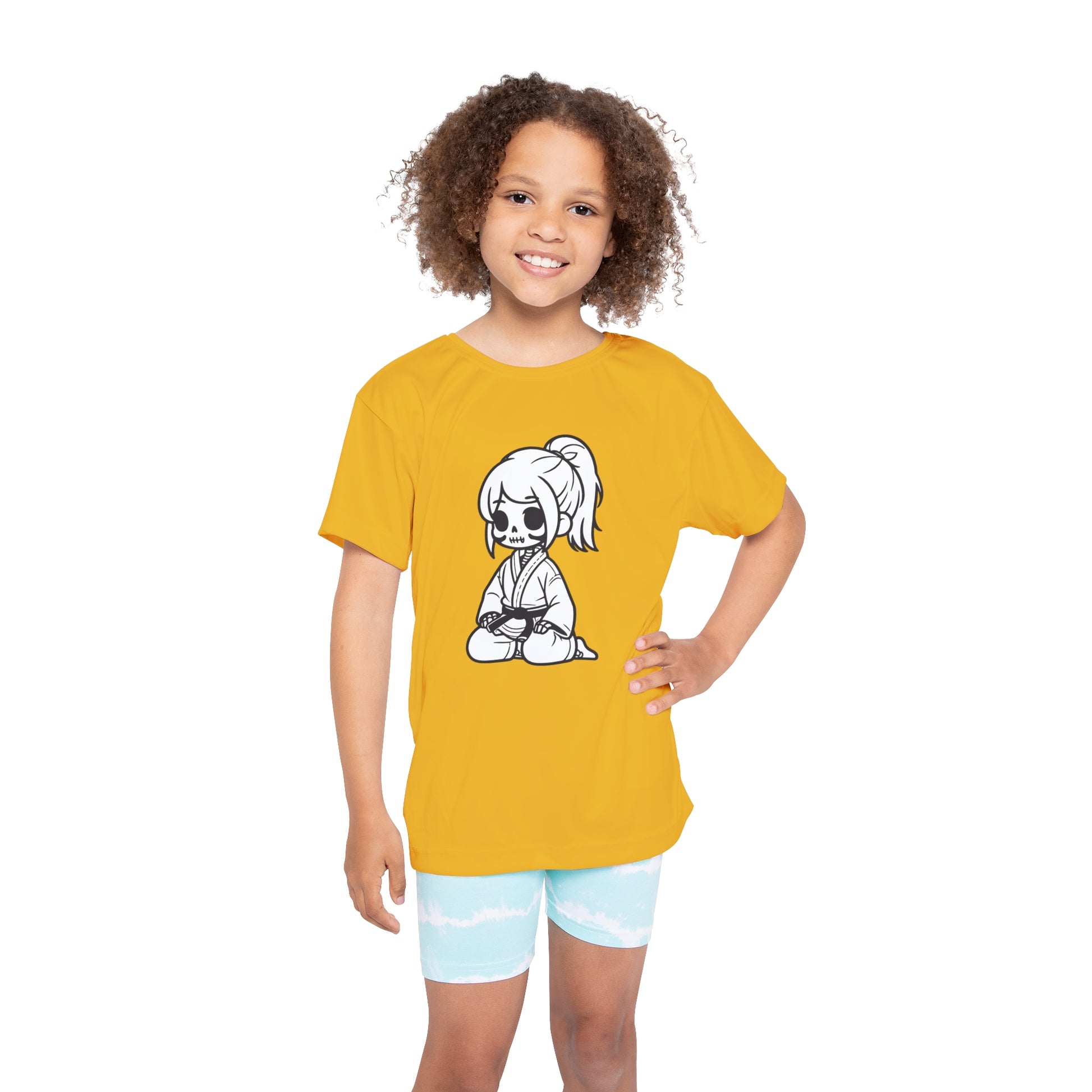 Front view of a girl wearing a yellow, polyester kids t-shirt, with a design of a skeleton girl wearing a jiu jitsu gi and black belt on the front.