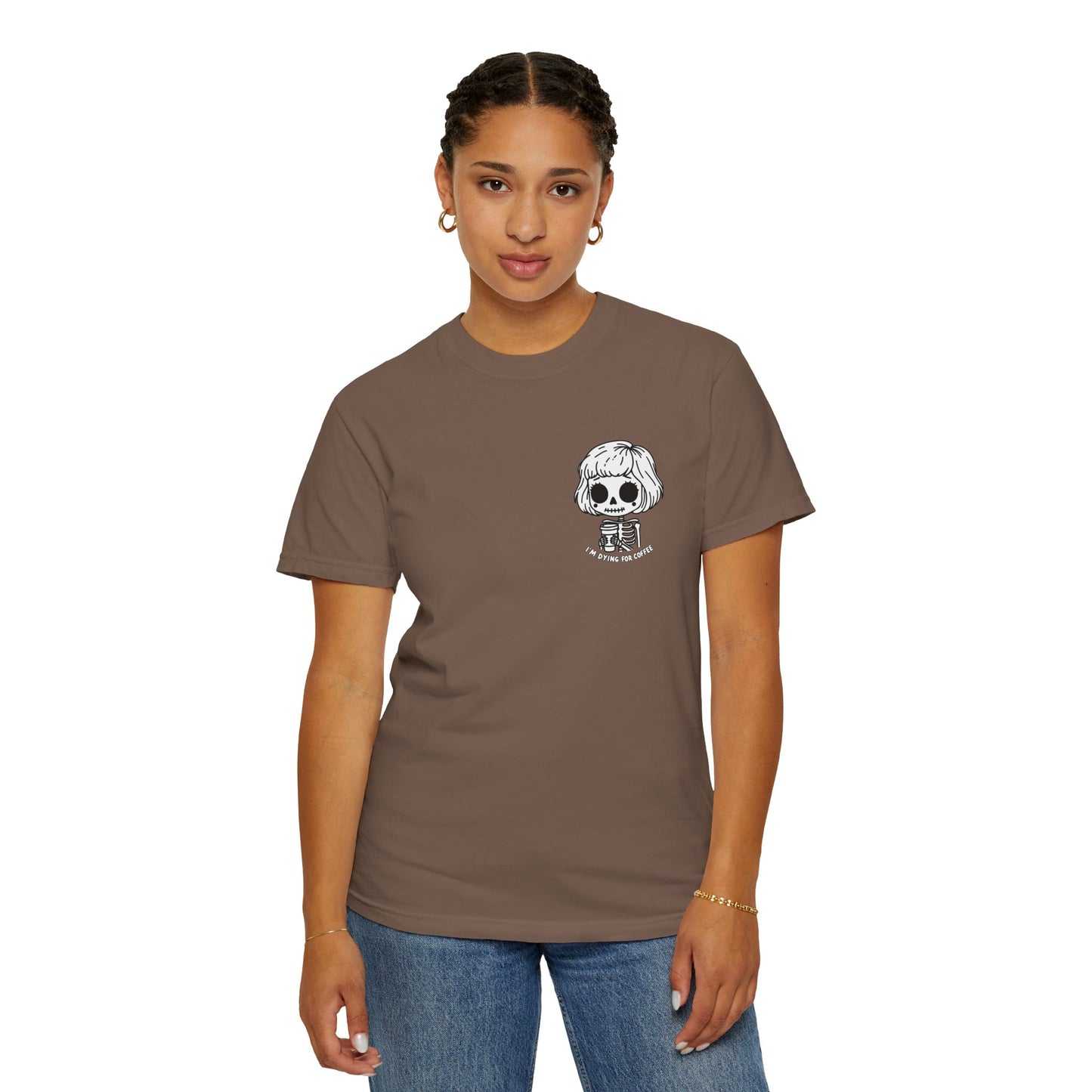 Alternate view of a woman wearing an Espresso colored t-shirt with a design of a skeleton girl holding a cup of coffee printed on the front. Written underneath the design is the text, "I'm dying for coffee". The design is placed on the left chest area of the t-shirt.