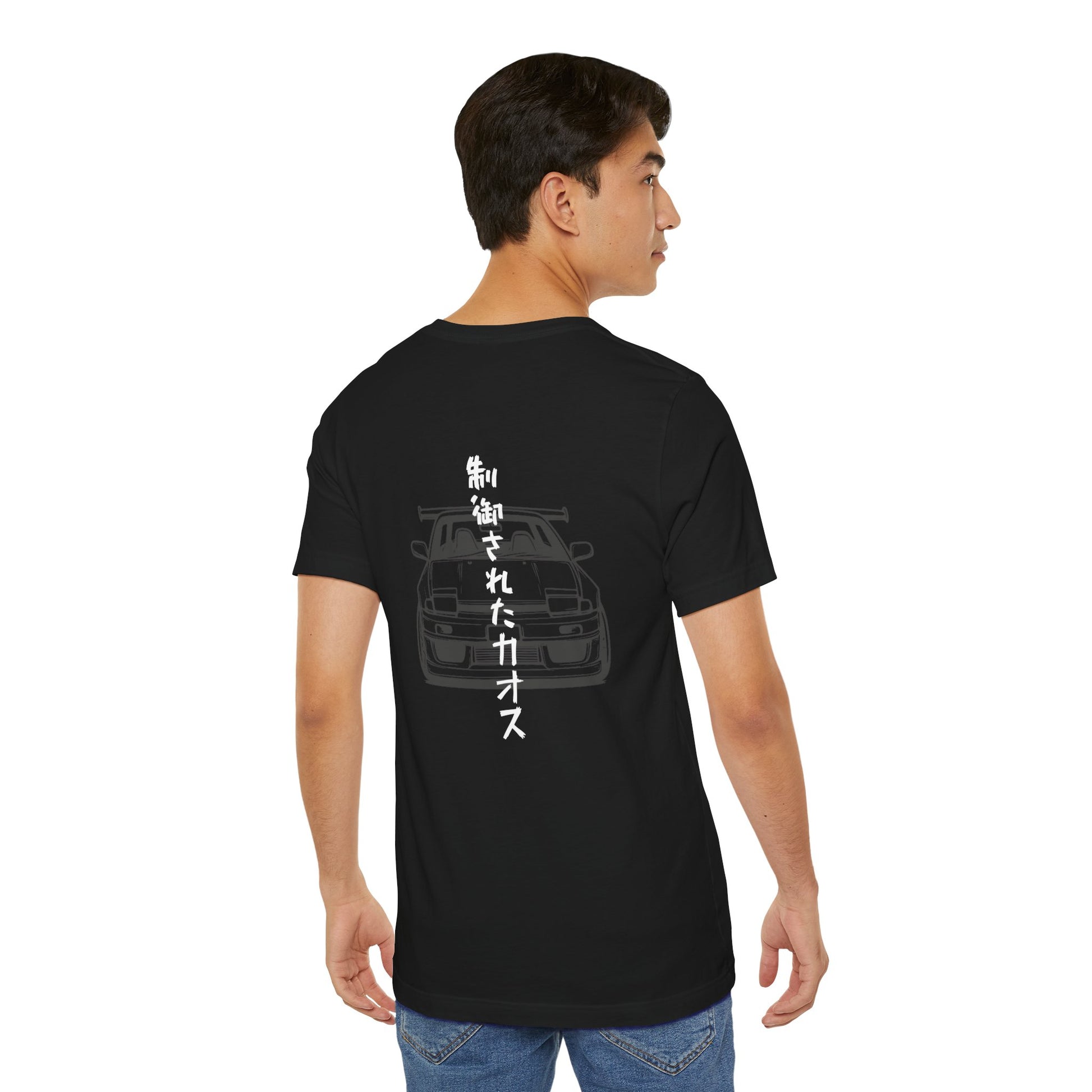 Back view of a man wearing a black t-shirt with an illustration of a drift car, and the words "Controlled Chaos" written vertically in Japanese characters.