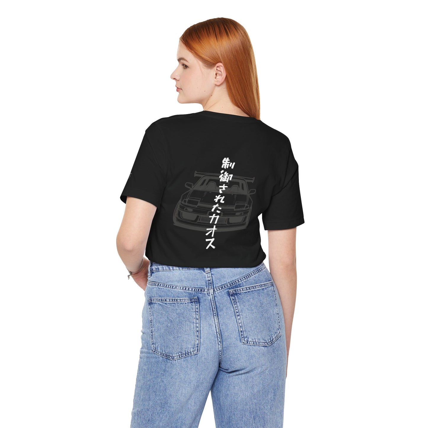 Back view of a woman wearing a black t-shirt with an illustration of a drift car, and the words "Controlled Chaos" written vertically in Japanese characters.