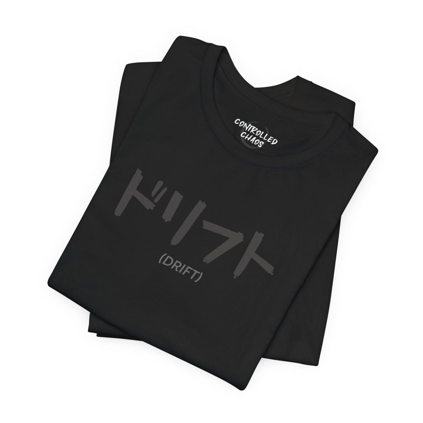 A folded, black t-shirt with text printed on the chest that spells Drift in Japanese.