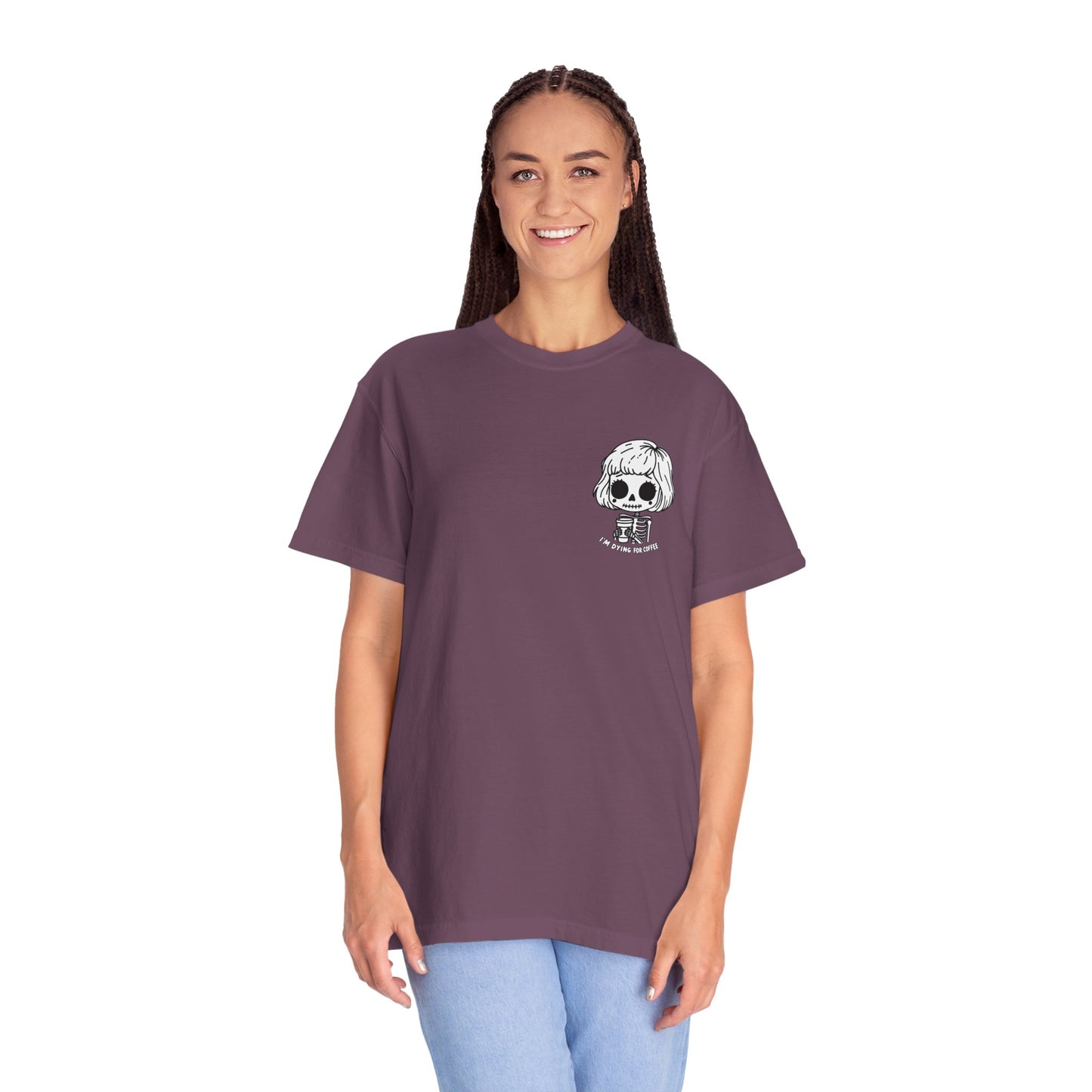 Alternate view of a tall, thin woman wearing a berry colored t-shirt with a design of a skeleton girl holding a cup of coffee printed on the front. Written underneath the design is the text, "I'm dying for coffee". The design is placed on the left chest area of the t-shirt.