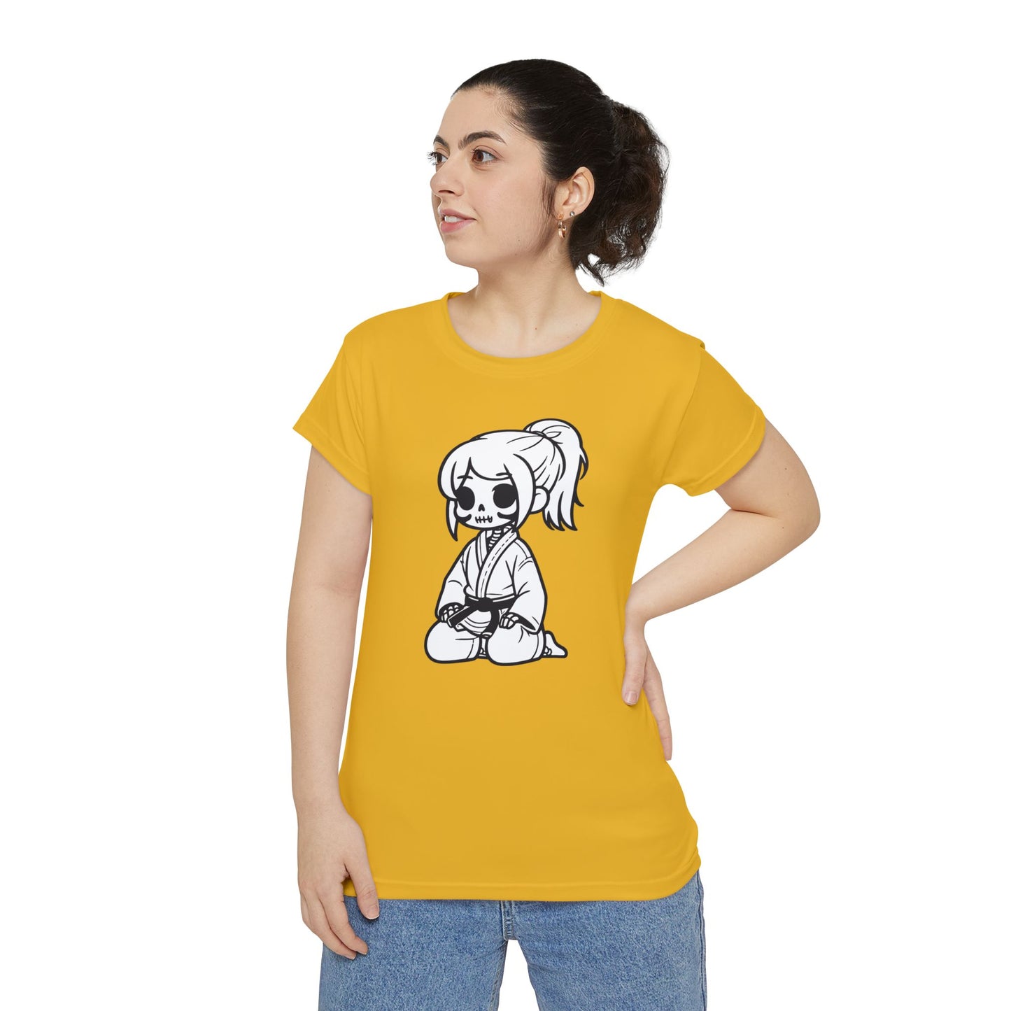 Front view of a woman wearing a yellow polyester blend t-shirt, with a design of a skeleton girl wearing a jiu jitsu gi and black belt on the front.