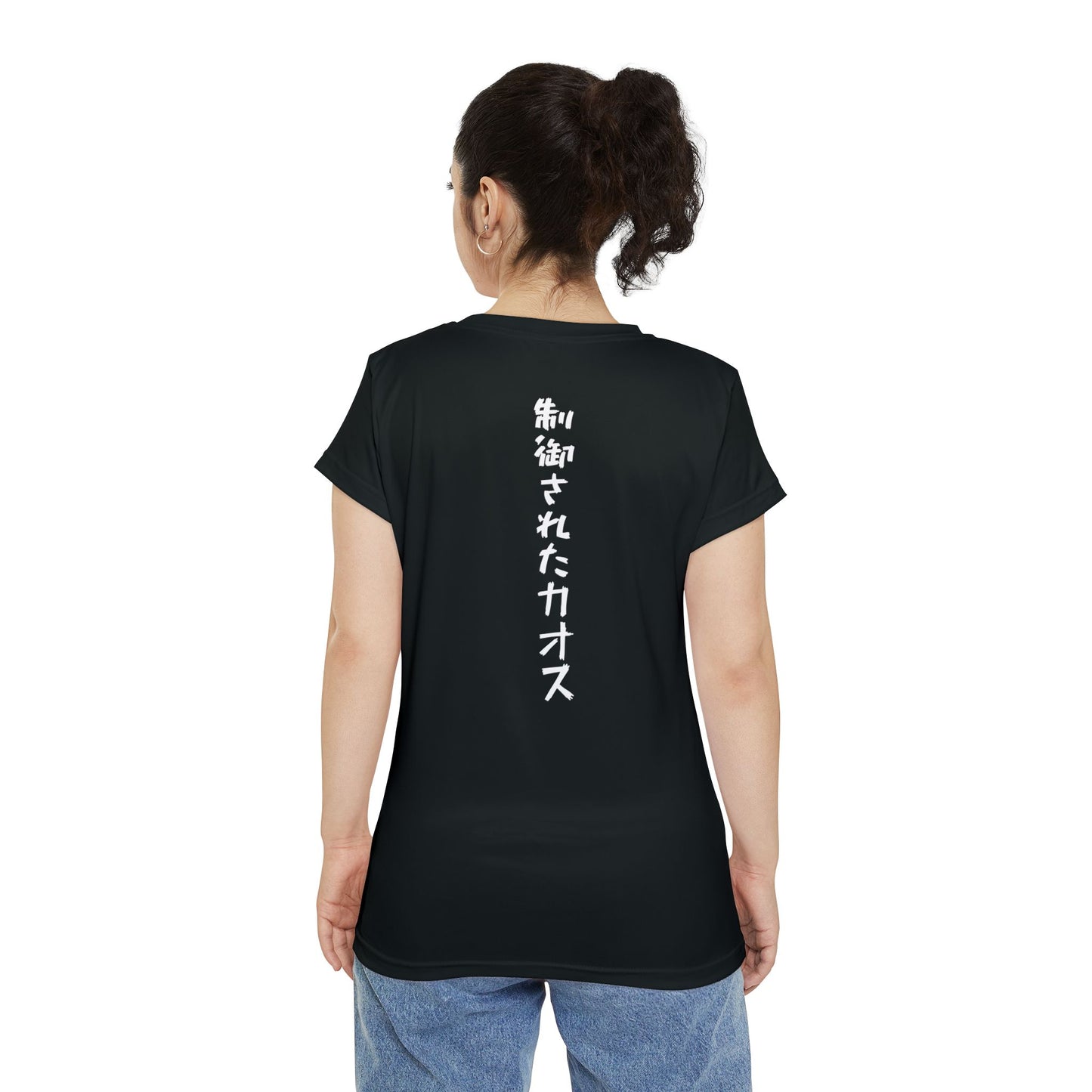 Back view of a woman wearing a black, polyester blend t-shirt, with the words "Controlled Chaos" written vertically down the middle of the shirt in Japanese.