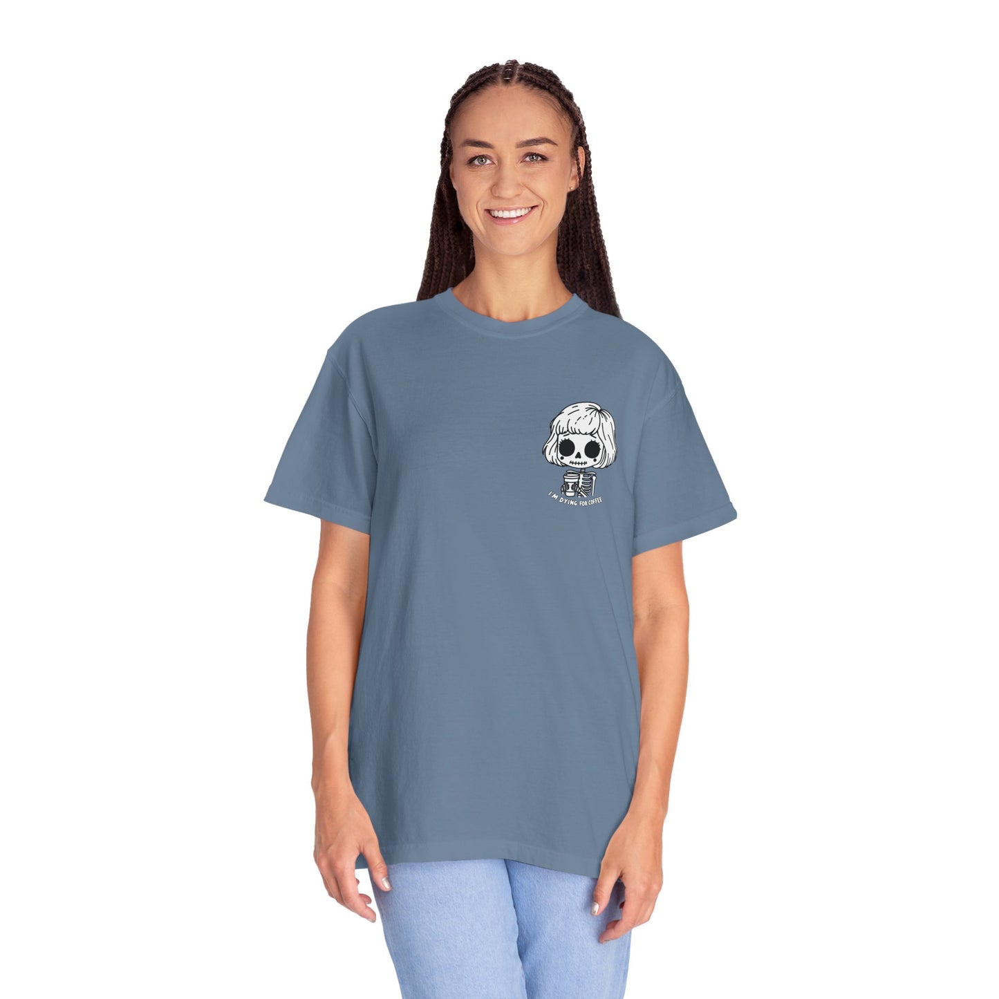 Alternate view of a tall, thin woman wearing a Blue Jean colored t-shirt with a design of a skeleton girl holding a cup of coffee printed on the front. Written underneath the design is the text, "I'm dying for coffee". The design is placed on the left chest area of the t-shirt.