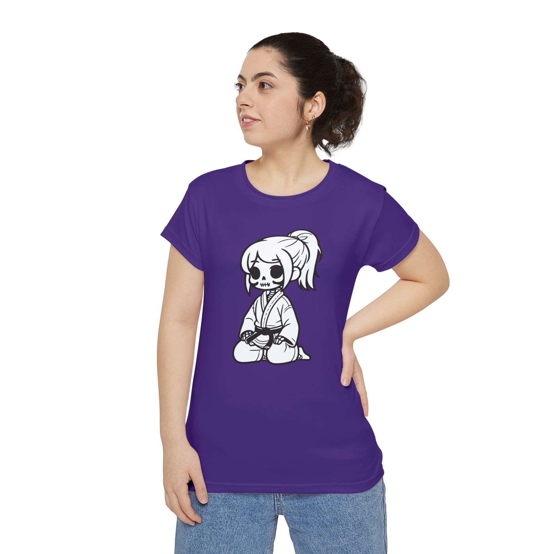 Front view of a woman wearing a purple, polyester blend t-shirt with a design of a skeleton girl wearing a jiu jitsu gi and black belt on the front.