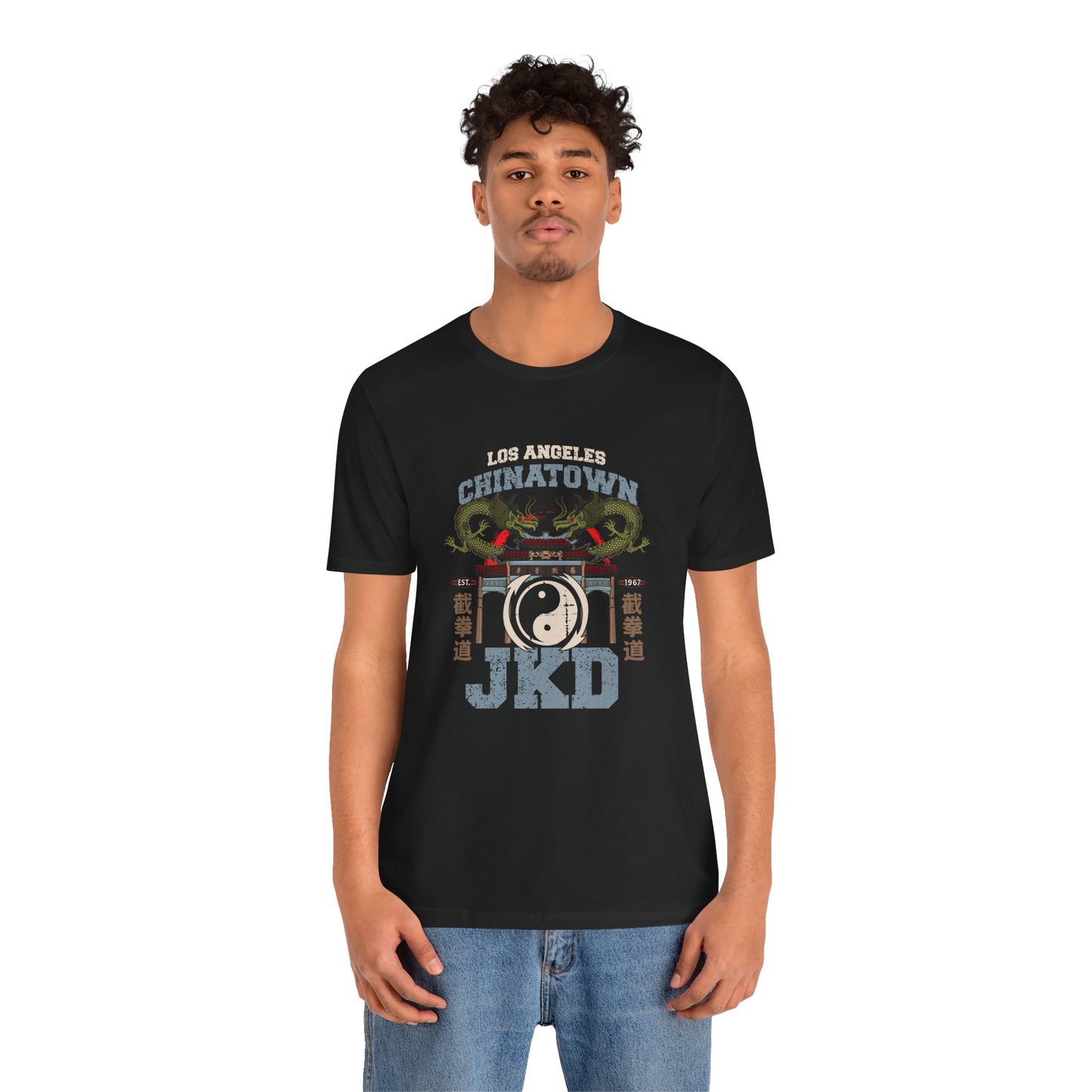 Front view of a man wearing a black cotton t-shirt, with a design of twin dragons standing behind the L.A. Chinatown West Gate. The text above and below reads "Los Angeles Chinatown JKD". On the left and right sides are Chinese characters spelling Jeet Kune Do.