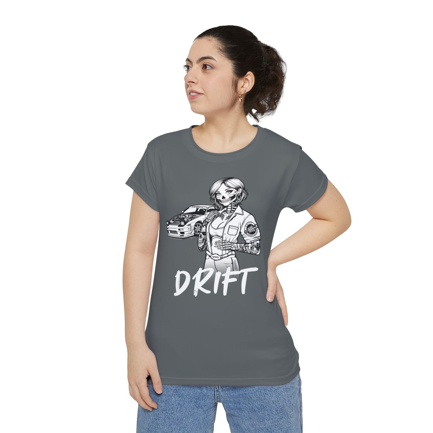 Front view of a woman wearing a dark gray, polyester blend t-shirt, with a design of a female skeleton dressed as a mechanic. The mechanic is standing next to her car with the word "Drift" written underneath.